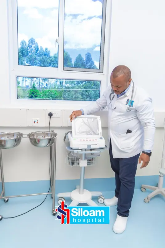 Doctor at Siloam Hospital examining diagnostic equipment in a patient room